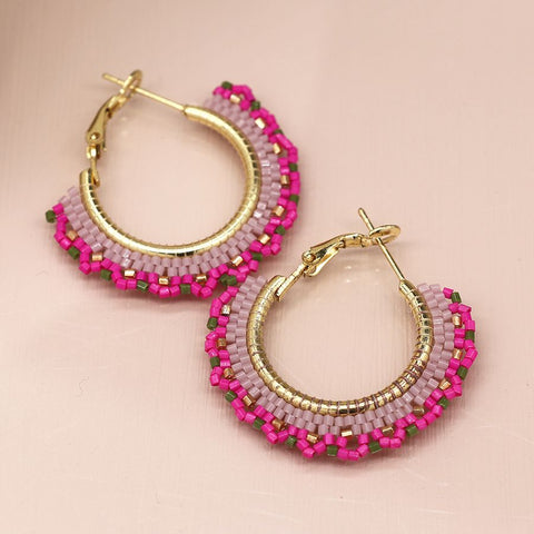 Elevate your style with our Beaded Fan Hoop Earrings in Pink! These golden hoop earrings feature a stunning pink mix striped multi bead fan detail that will add a touch of elegance and playfulness to any outfit. Make a statement and turn heads with these unique and eye-catching earrings.