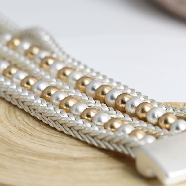 Mixed gold and silver finish round bead multi strand bracelet with silver chains and a magnetic clasp.